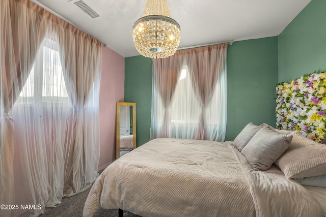 carpeted bedroom with an inviting chandelier