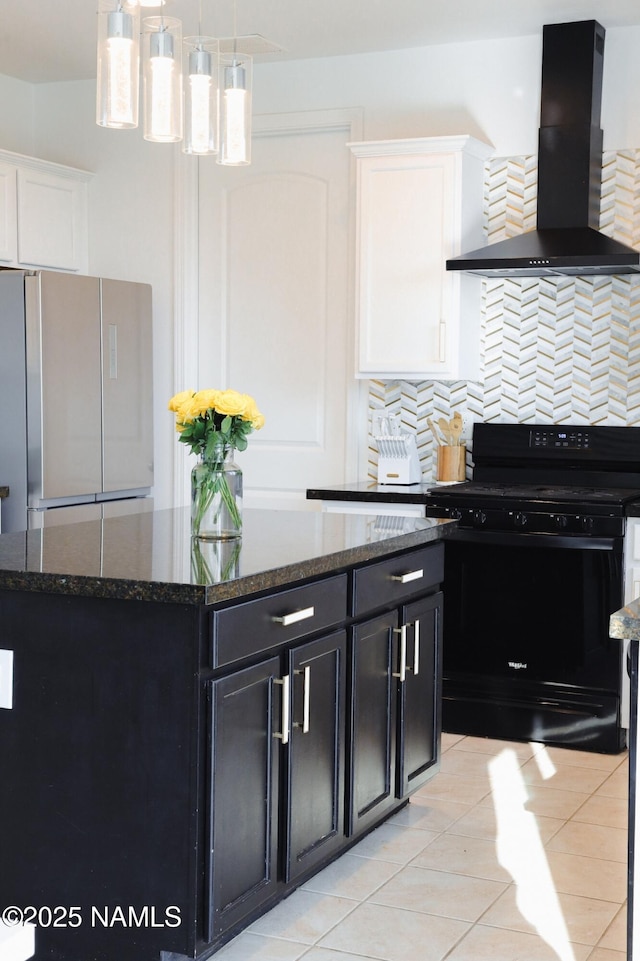 11941 Pegasus Rd, Bellemont, AZ 86015 - kitchen featuring black gas range oven, wall chimney exhaust hood, freestanding refrigerator, dark cabinets, and tasteful backsplash