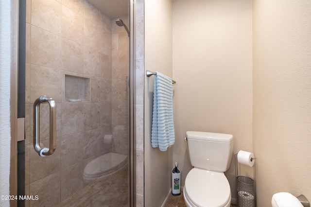 bathroom featuring toilet and a shower stall