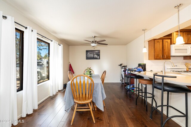 dining space with dark wood-type flooring and a ceiling fan