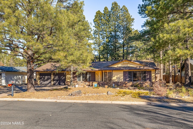 single story home featuring a garage and fence