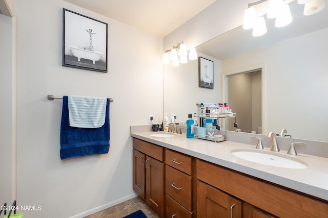 full bathroom with tile patterned floors, a sink, baseboards, and double vanity