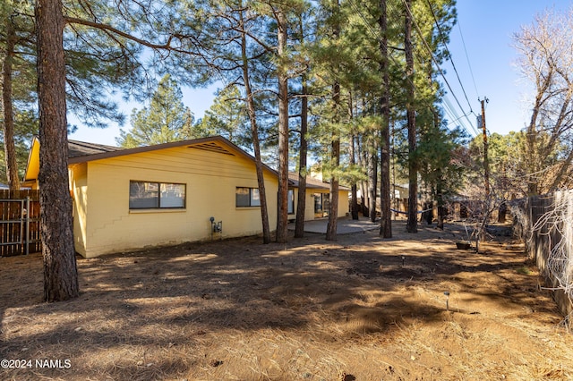 view of home's exterior with fence and a patio