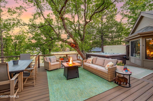 706 N Hulet Ln, Flagstaff, AZ 86004 - deck at dusk featuring a hot tub, an outdoor living space with a fire pit, and outdoor dining area