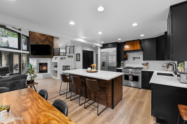 706 N Hulet Ln, Flagstaff, AZ 86004 - kitchen with high quality appliances, dark cabinetry, custom exhaust hood, light countertops, and recessed lighting