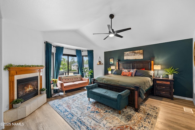706 N Hulet Ln, Flagstaff, AZ 86004 - bedroom featuring lofted ceiling, wood finished floors, a tiled fireplace, and a ceiling fan