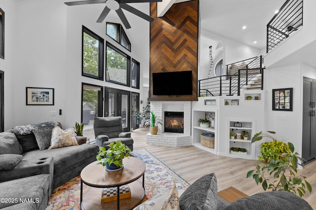706 N Hulet Ln, Flagstaff, AZ 86004 - living room featuring a high ceiling, light wood-style floors, a ceiling fan, built in shelves, and a fireplace