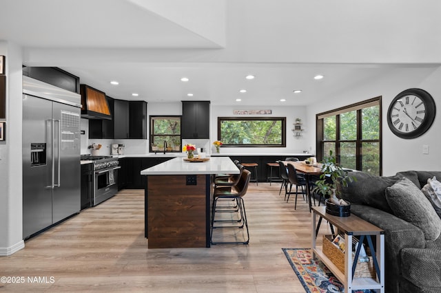 706 N Hulet Ln, Flagstaff, AZ 86004 - kitchen featuring high quality appliances, premium range hood, recessed lighting, light countertops, and healthy amount of natural light