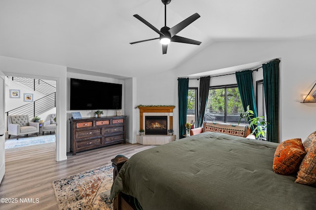 706 N Hulet Ln, Flagstaff, AZ 86004 - bedroom featuring wood finished floors, a tile fireplace, ceiling fan, and high vaulted ceiling