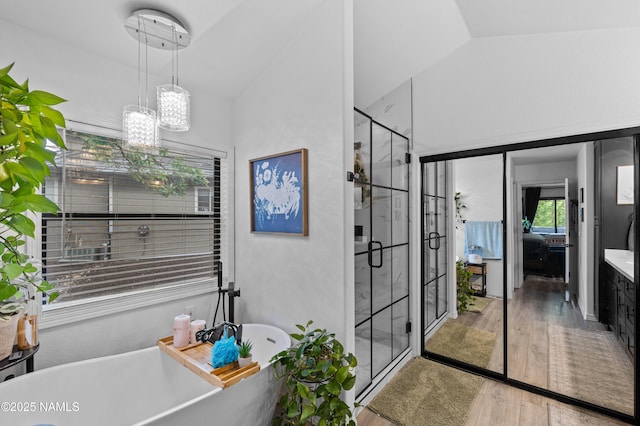 706 N Hulet Ln, Flagstaff, AZ 86004 - full bathroom featuring vaulted ceiling, wood finished floors, a soaking tub, a shower stall, and ensuite bathroom