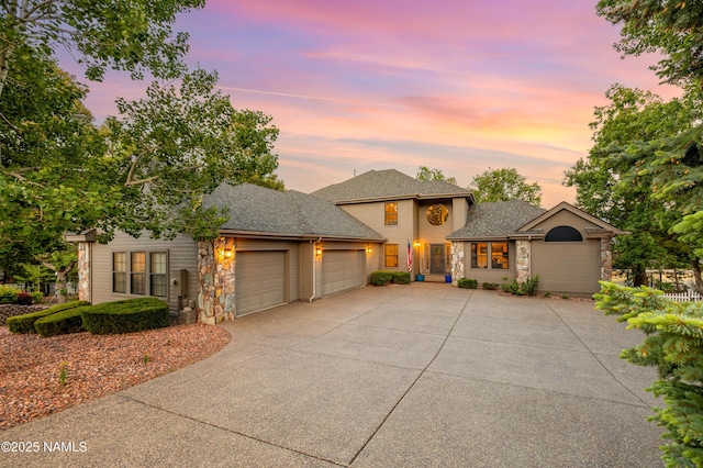 706 N Hulet Ln, Flagstaff, AZ 86004 - traditional home with an attached garage, driveway, stone siding, and roof with shingles