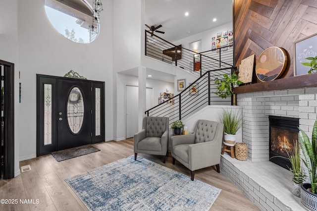 706 N Hulet Ln, Flagstaff, AZ 86004 - foyer featuring a towering ceiling, stairway, wood finished floors, a brick fireplace, and baseboards
