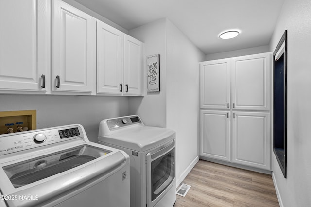 706 N Hulet Ln, Flagstaff, AZ 86004 - laundry area with cabinet space, separate washer and dryer, light wood-style flooring, and baseboards