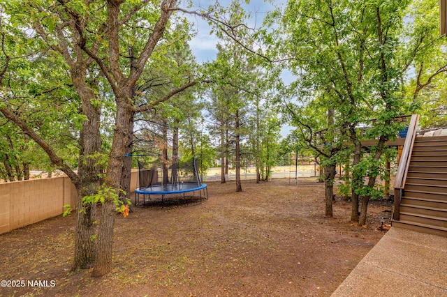 706 N Hulet Ln, Flagstaff, AZ 86004 - fenced backyard featuring a trampoline and stairway