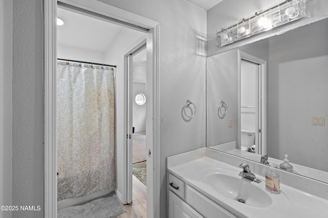 706 N Hulet Ln, Flagstaff, AZ 86004 - bathroom featuring vanity, a textured wall, wood finished floors, and toilet
