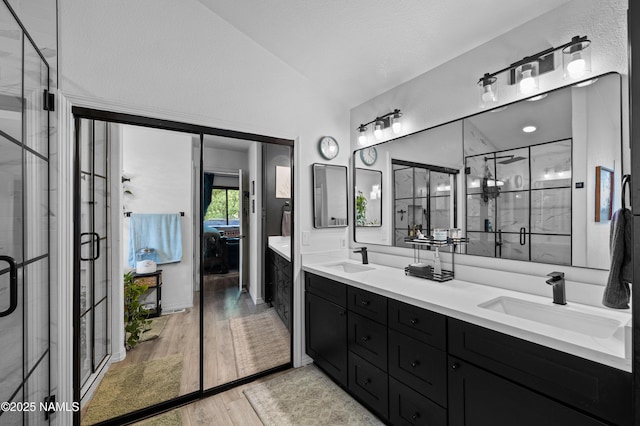 706 N Hulet Ln, Flagstaff, AZ 86004 - full bathroom with vaulted ceiling, double vanity, wood finished floors, a stall shower, and ensuite bathroom