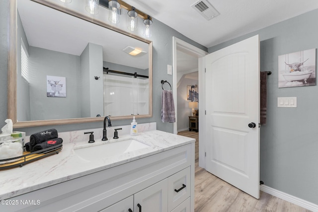 bathroom with vanity, hardwood / wood-style floors, and a shower