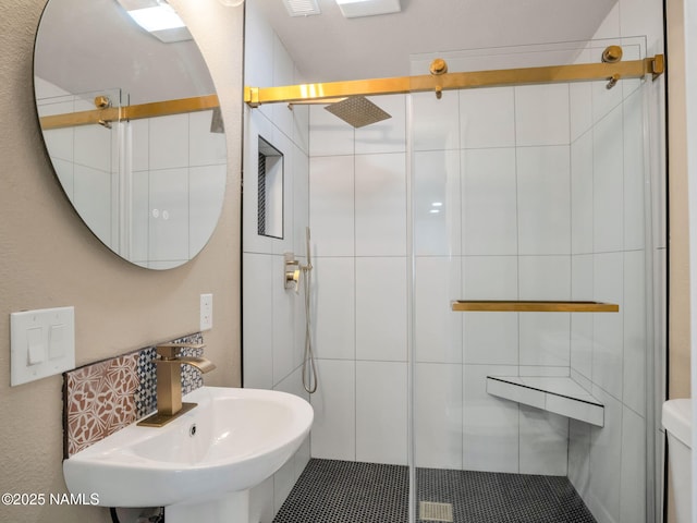 bathroom with sink and a shower with shower door