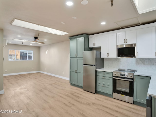 kitchen with stainless steel appliances, decorative backsplash, and green cabinetry