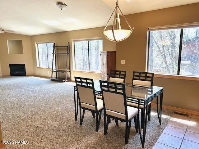 39 E Oak Dr, Munds Park, AZ 86017 - dining space with a ceiling fan, light tile patterned floors, a fireplace, baseboards, and visible vents