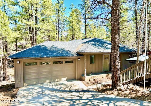 39 E Oak Dr, Munds Park, AZ 86017 - view of front of home featuring concrete driveway, an attached garage, and roof with shingles