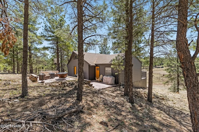 5552 White Tail Ln, Flagstaff, AZ 86005 - view of side of property featuring a patio, a shingled roof, and outdoor lounge area