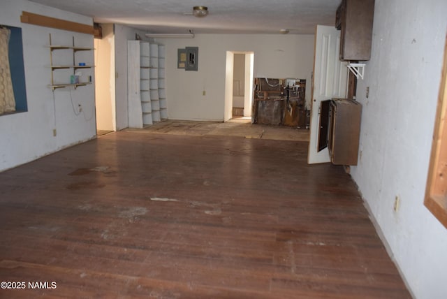 interior space featuring electric panel, heating unit, and wood finished floors