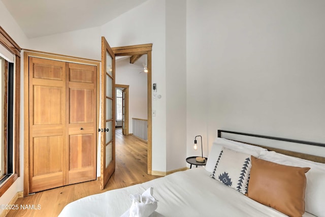 bedroom with lofted ceiling and light hardwood / wood-style flooring