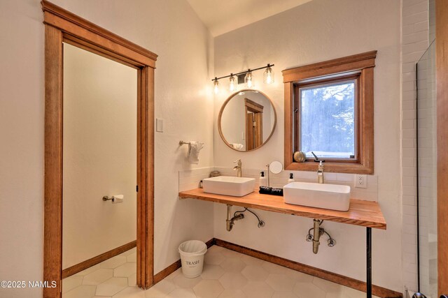 bathroom with dual sinks and backsplash