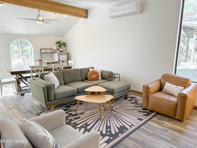 living room with vaulted ceiling with beams, light hardwood / wood-style flooring, a wall unit AC, and ceiling fan