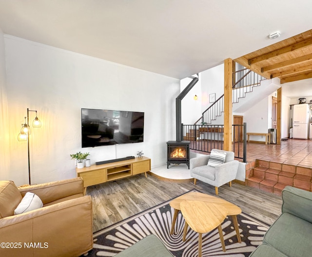 living room with hardwood / wood-style flooring, wooden ceiling, beamed ceiling, and a wood stove