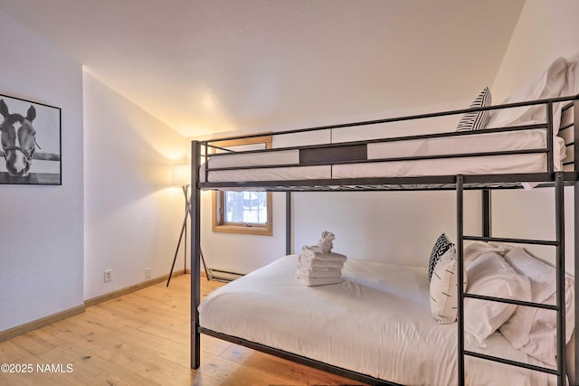 bedroom featuring a baseboard radiator and light hardwood / wood-style floors