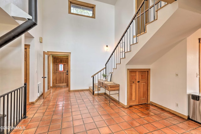 tiled entryway featuring a high ceiling