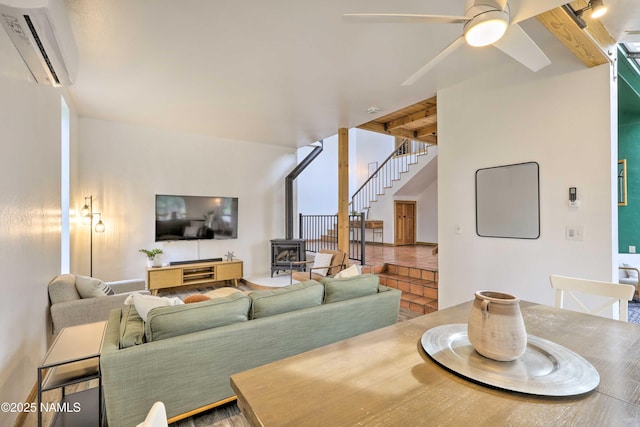 dining space featuring ceiling fan, an AC wall unit, a wood stove, and beam ceiling