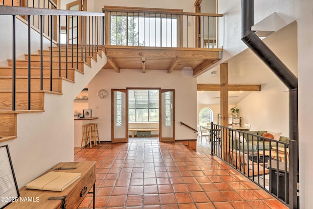 tiled foyer featuring beam ceiling