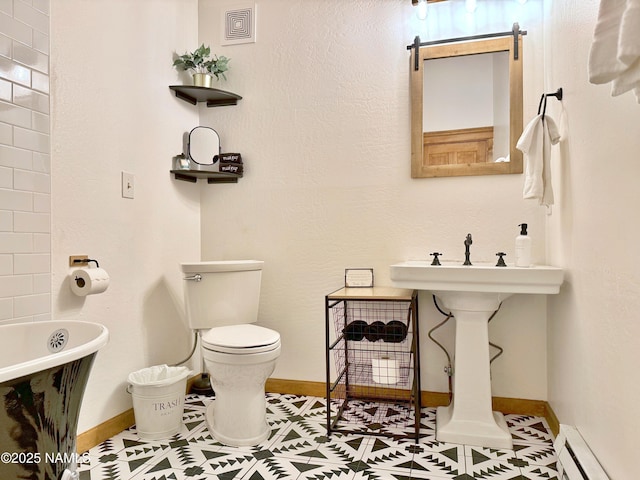 bathroom featuring a baseboard heating unit, a bathtub, and toilet