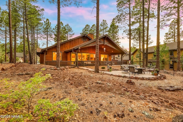 3480 W Lead Rope, Flagstaff, AZ 86005 - back of house at dusk with an outdoor living space and a patio area