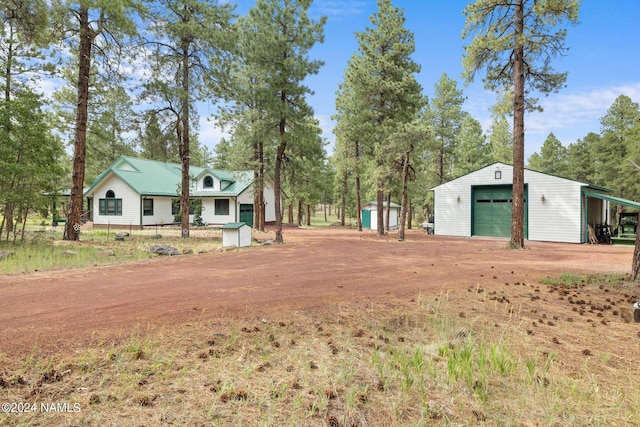 view of yard featuring a garage, an outdoor structure, and driveway