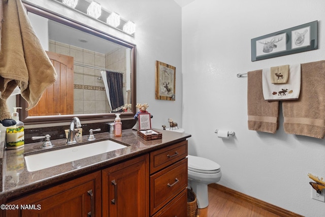 full bathroom with curtained shower, baseboards, toilet, wood finished floors, and vanity