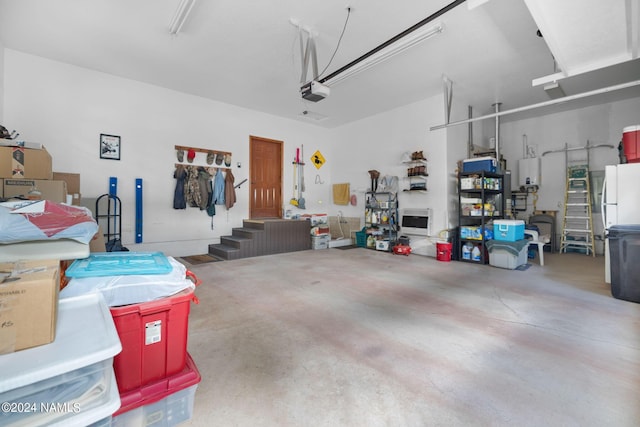 garage with a garage door opener and freestanding refrigerator