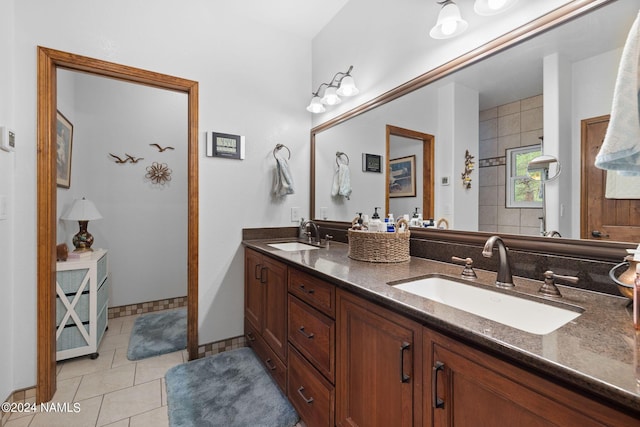 full bath featuring tile patterned floors, double vanity, and a sink