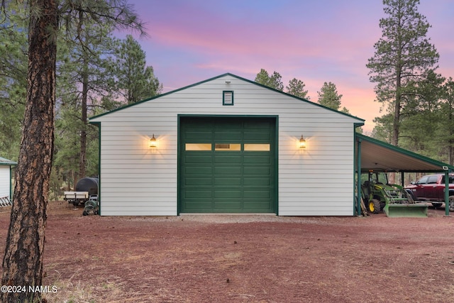 detached garage featuring a carport and dirt driveway