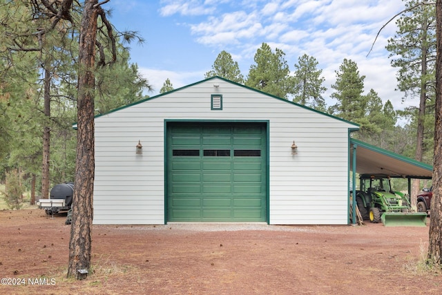 detached garage with a carport and dirt driveway