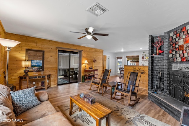 840 E Caribou Rd, Munds Park, AZ 86017 - living area featuring wooden walls, wood finished floors, ceiling fan, a brick fireplace, and recessed lighting