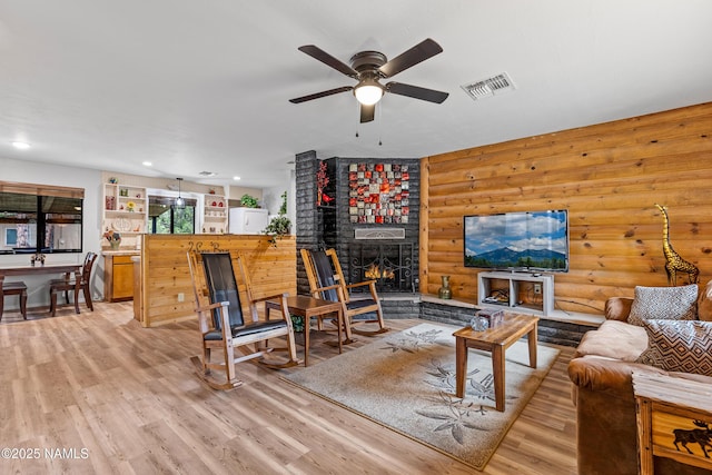 840 E Caribou Rd, Munds Park, AZ 86017 - living area featuring log walls, a ceiling fan, light wood-type flooring, a fireplace, and recessed lighting