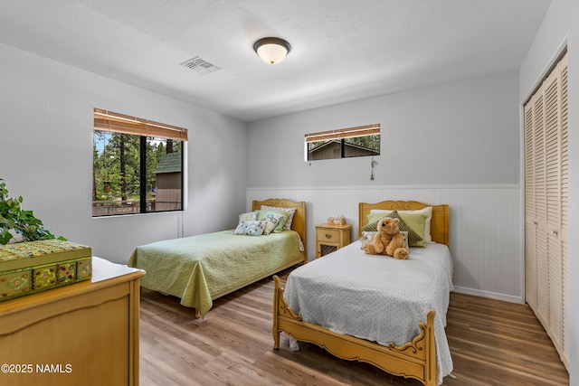 840 E Caribou Rd, Munds Park, AZ 86017 - bedroom with light wood-style floors, wainscoting, a closet, and baseboards