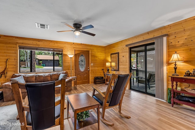 840 E Caribou Rd, Munds Park, AZ 86017 - living area featuring healthy amount of natural light, a ceiling fan, wooden walls, and light wood-style floors