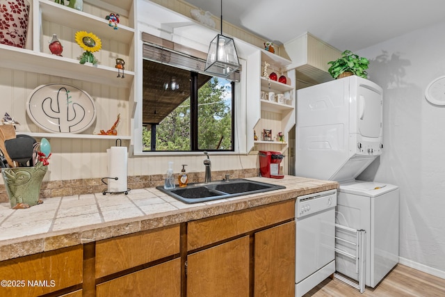 840 E Caribou Rd, Munds Park, AZ 86017 - kitchen with open shelves, stacked washer and clothes dryer, dishwasher, a sink, and light wood finished floors