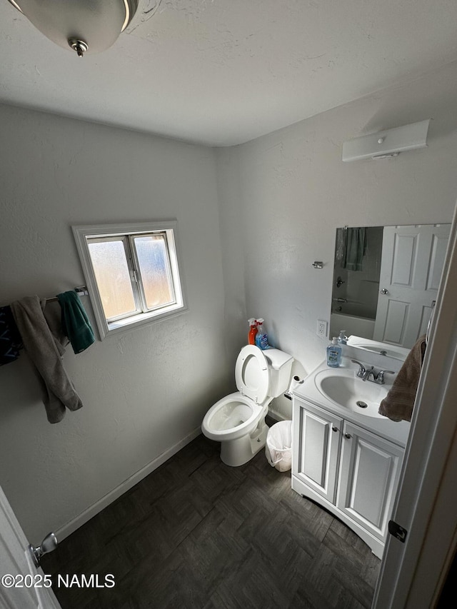 full bath with toilet, baseboards, and vanity