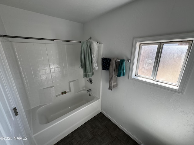 bathroom featuring shower / bath combination and baseboards